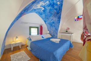 San Donato di LecceMasseria Le Palmentelle Pool And Garden - Happy Rentals的配有一张波浪画床的房间