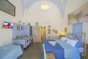 San Donato di LecceMasseria Le Palmentelle Pool And Garden - Happy Rentals的一间位于客房内的蓝色床卧室