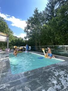 un gruppo di persone che giocano in piscina di Hotel Obermayr a Ebenau