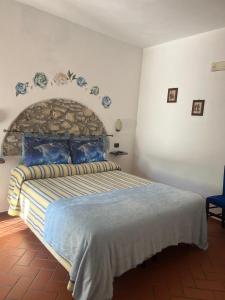 sypialnia z dużym łóżkiem z kamiennym zagłówkiem w obiekcie Agriturismo La Castellina w mieście Saturnia