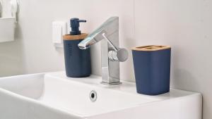 a sink with a faucet and two cups on it at Nossa Casa by Casas dos Lebre in Porto Santo +44 photos