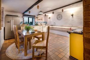 a kitchen with a table and chairs in a room at The Gilpin Farmhouse, Lake District Getaway in Levens