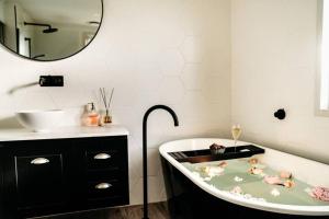 a bathroom with a bath tub with dolls in it at Luxury Treetop Escape with a Garden glasshouse in Kalorama +53 photos