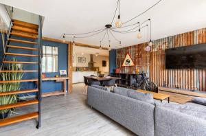 a living room with a couch and a tv at Le Rétro à Kaysersberg in Kaysersberg