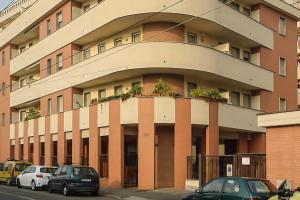 a large building with cars parked in front of it at Certosa House - Milano in Milan