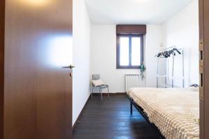 a bedroom with a bed and a sliding door at Certosa House - Milano in Milan
