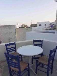 a white table and chairs sitting on a roof at Unique small stonehouse at Thira in Megalochori +27 photos