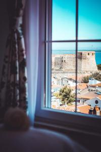 a window with a view of a city and a castle at Bozcaada Fresh Otel in Canakkale