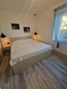 a bedroom with a bed and a window at Apartmani Rukavina in Rab