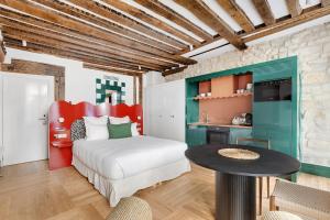 a bedroom with a bed and a table and a kitchen at Paris Home Collection Serviced Apartments in Notre Dame - Rue Savoie in Paris