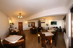 a dining room with wooden tables and chairs at Pensiunea Muntele Alb in Horezu