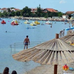 a group of people in the water at a beach at Apartment Ivan in Sukošan