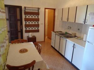 a kitchen with a table and a sink and a refrigerator at Apartment Ivan in Sukošan +2 photos