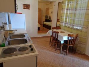 a kitchen with a sink and a table with chairs at Apartment Ivan in Sukošan