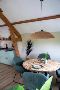 a dining room with a wooden table and chairs at De Mölle in Winterswijk +12 photos