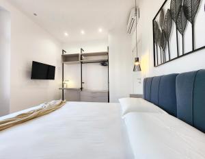 ein Schlafzimmer mit einem Bett und einem Fernseher an der Wand in der Unterkunft Matteotti Royale Apartments in Syrakus