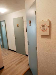 an empty room with two doors and a sign on the wall at OVGMontgenevre in Montgenèvre