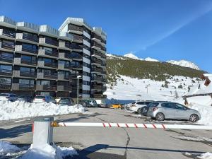 a parking lot with cars parked in front of a building at OVGMontgenevre in Montgenèvre