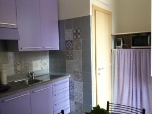 a kitchen with purple cabinets and a sink at Comodità città-mare Cinque Terre in La Spezia