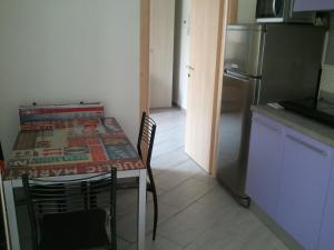 eine Küche mit einem Tisch mit Stühlen und einem Kühlschrank in der Unterkunft Comodità città-mare Cinque Terre in La Spezia