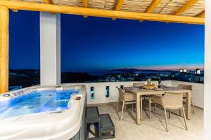 a patio with a hot tub and a table and chairs at Penelope Apartments D in Vívlos