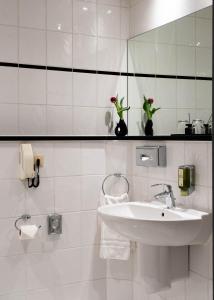 ein weißes Badezimmer mit Waschbecken und Spiegel in der Unterkunft Hotel Ottheinrich in Weinheim