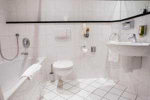 ein weißes Badezimmer mit Toilette und Waschbecken in der Unterkunft Hotel Ottheinrich in Weinheim