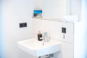 a white bathroom with a sink and white cabinets at Zentral - für 6 - 2x frei parken - Terrasse in Gießen +21 photos