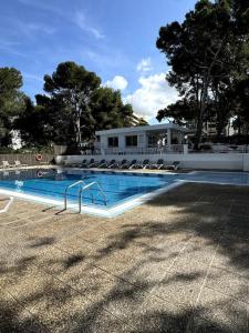 ein großes Schwimmbad mit Stühlen und einem Gebäude in der Unterkunft Premium Luxury Residence RITS in Salou