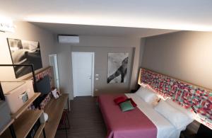 a small room with a bed with a red blanket at Bed In Centro in Naples