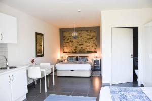 a bedroom with a bed and a table and a kitchen at Casa nas Serras in Vila Nova de Poiares