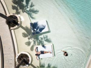 an overhead view of a pool with two people in the water at Cora Hotel & Spa in Afitos