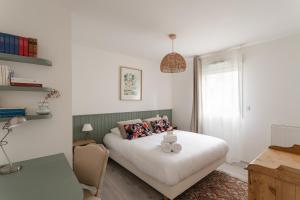 a bedroom with a bed with two candles on it at Les Sternes - Appt proche de la plage in Saint Malo