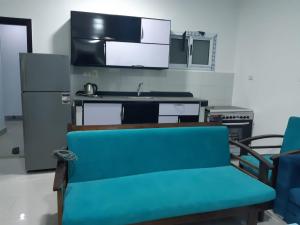 a kitchen with a blue couch and a refrigerator at الغردقة الدهار القيادات in Hurghada +2 photos
