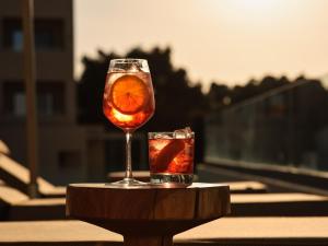 a glass of drink on a table with an orange slice at Cora Hotel & Spa in Afitos