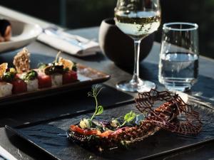a table with two plates of food and a glass of wine at Cora Hotel & Spa in Afitos