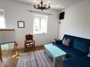 a living room with a blue couch and a table at O Ninho in Cepos