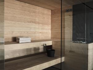 a bathroom with a shower with a wooden wall at Cora Hotel & Spa in Afitos