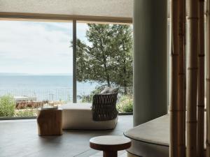 a living room with a large window and a couch at Cora Hotel & Spa in Afitos