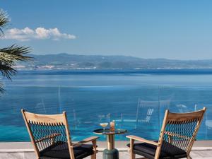 two chairs and a table with a view of the ocean at Cora Hotel & Spa in Afitos