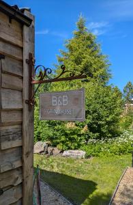un panneau indiquant bbc grindhurst devant une maison dans l'établissement BB Grindhuset, à Larvik