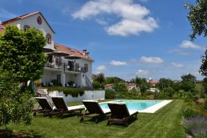 a villa with a swimming pool and lounge chairs at Casa nas Serras in Vila Nova de Poiares