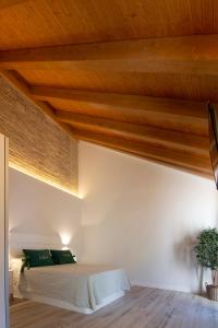 a bedroom with a bed with wooden ceilings at Vivienda Turística CASA QUEVEDO in Úbeda