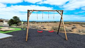 een schommelset met twee rode schommels bij Casa da Ponta by Casas dos Lebre in Porto Santo