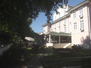 a building with people sitting on benches in front of it at Selcuk Uygulama Oteli̇ in Selçuk