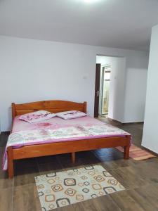 a bedroom with a bed with pink sheets and a rug at Camere de închiriat Alex in Costinesti +3 photos
