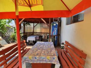 a table with an umbrella on a patio at Camere de închiriat Alex in Costinesti