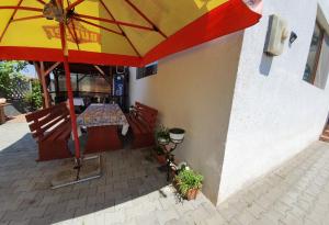 a restaurant with a table and a yellow and red umbrella at Camere de închiriat Alex in Costinesti