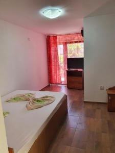 a bedroom with a bed and a television in a room at Camere de închiriat Alex in Costinesti