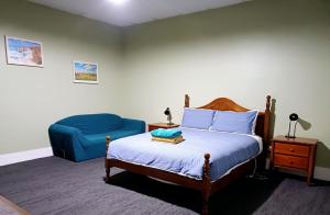 a bedroom with a bed and a blue chair at PETERBOROUGH HOTEL in Peterborough